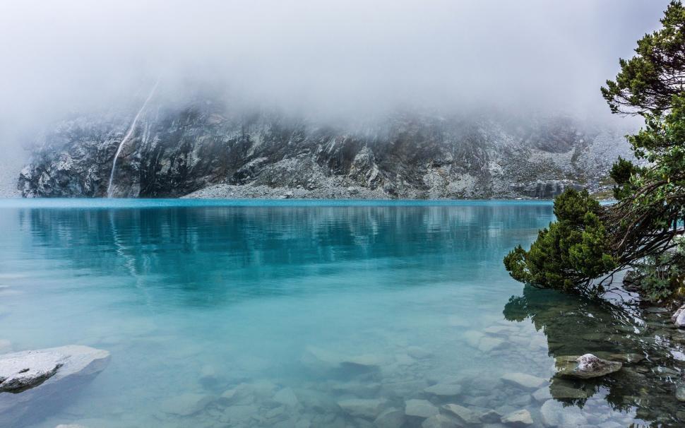 Free Image of Pristine Body of Water Surrounded by Snow Covered Mountains 