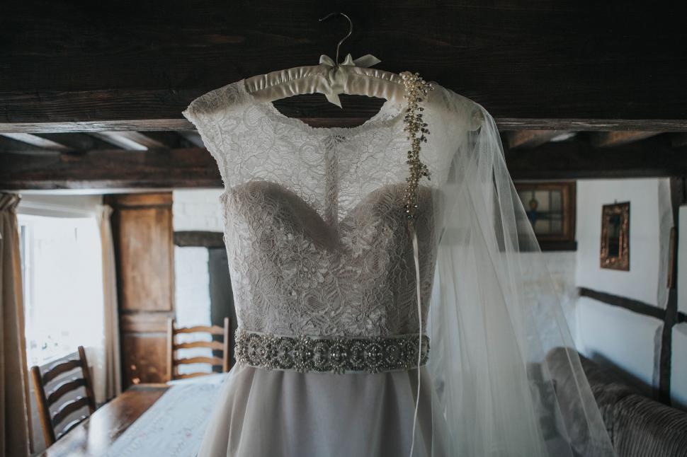 Free Image of Wedding Dress Hanging on Rack in Room 