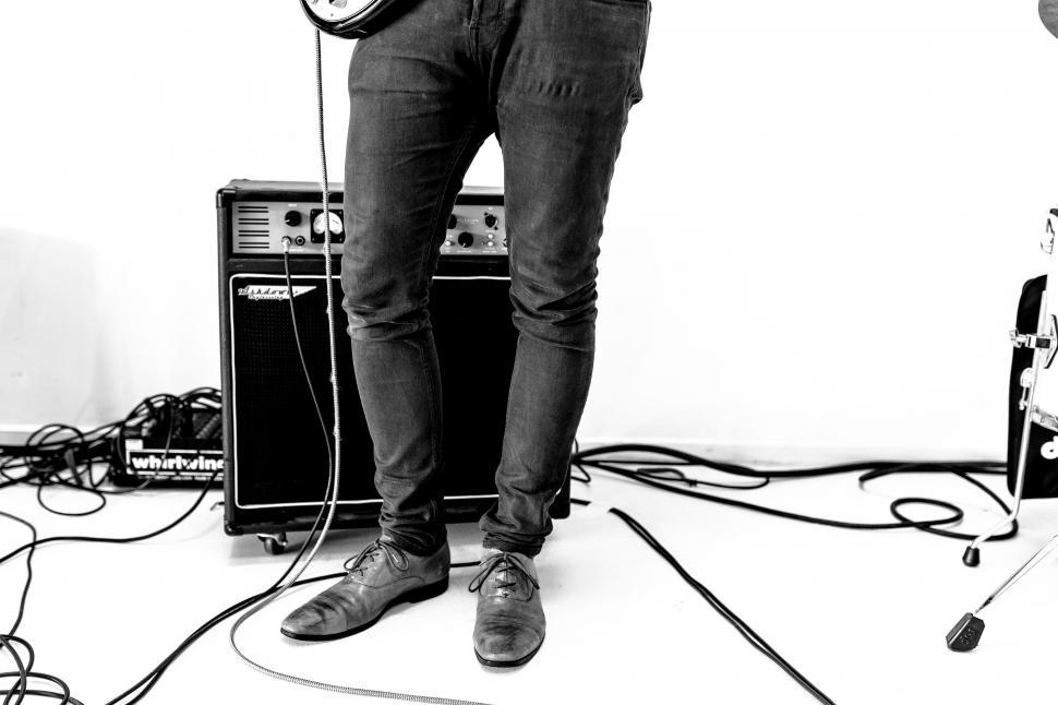 Free Image of Man Standing in Front of Guitar and Amp 