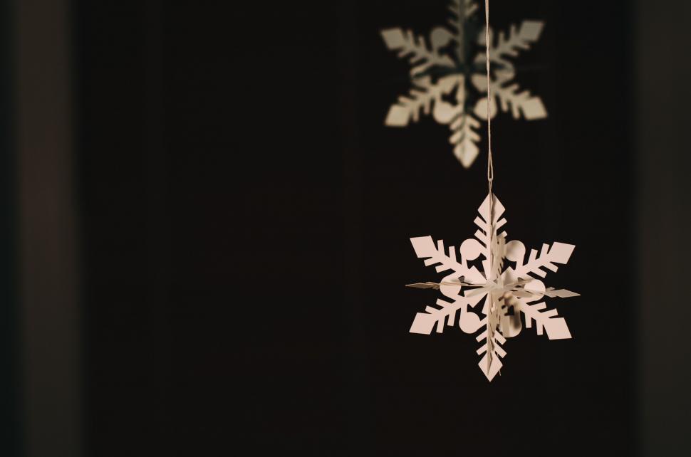 Free Image of White Snowflake Hanging From Black Wall 
