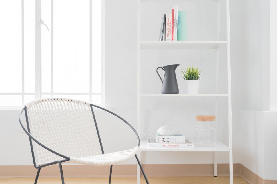 Free Image of White Chair in Front of Book Shelf 