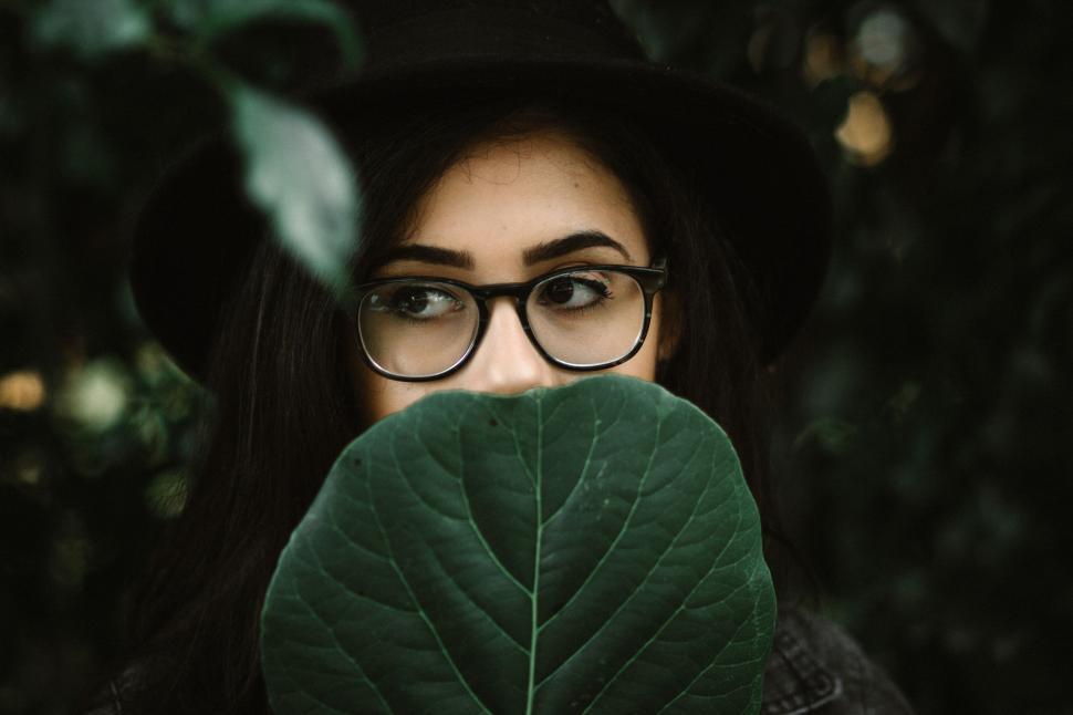 Free Image of Woman With Glasses Holding Leaf in Front of Face 