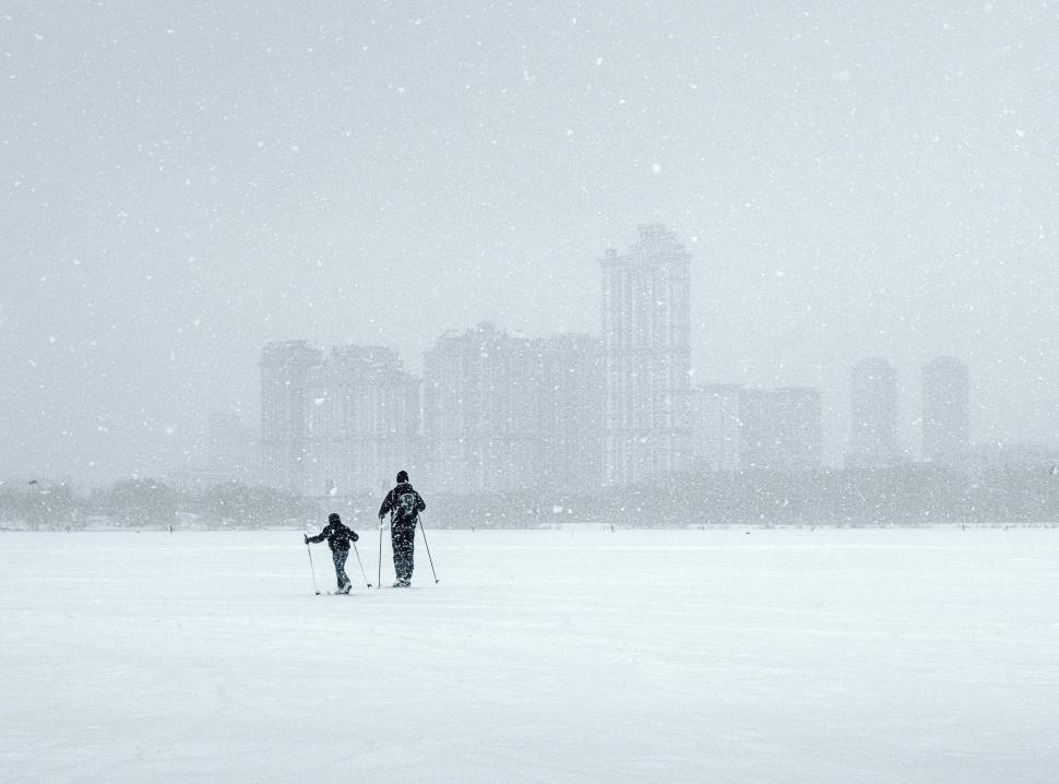 Free Image of Couple Walking Across Snow Covered Field 
