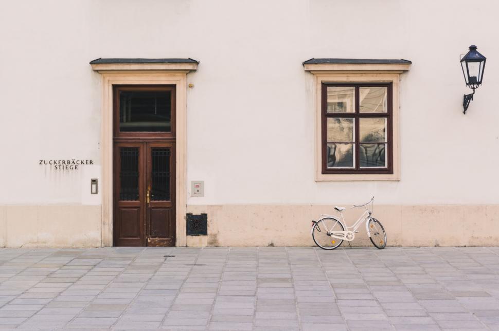 Free Image of Bicycle Parked in Front of White Building 