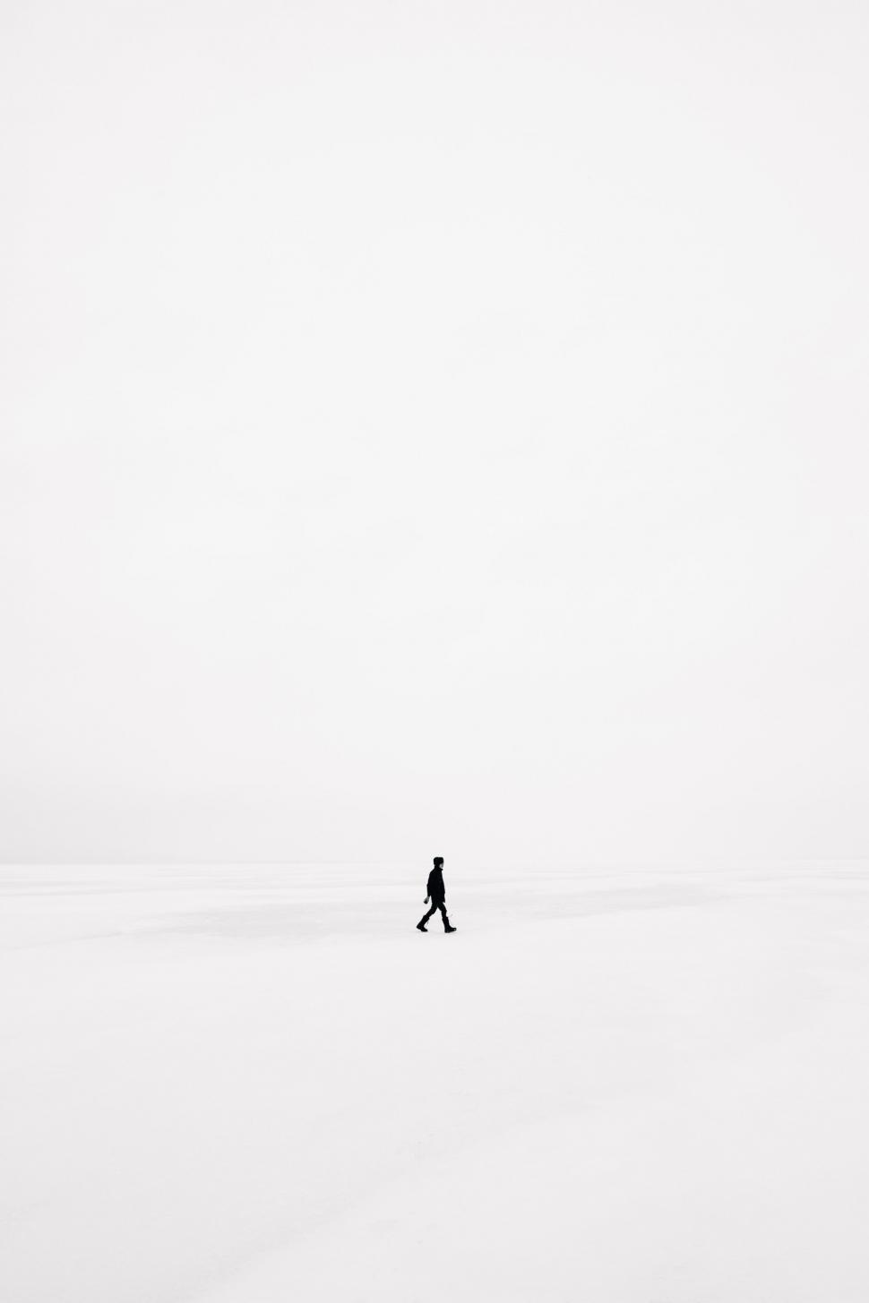 Free Image of Person Walking Across Snow Covered Field 
