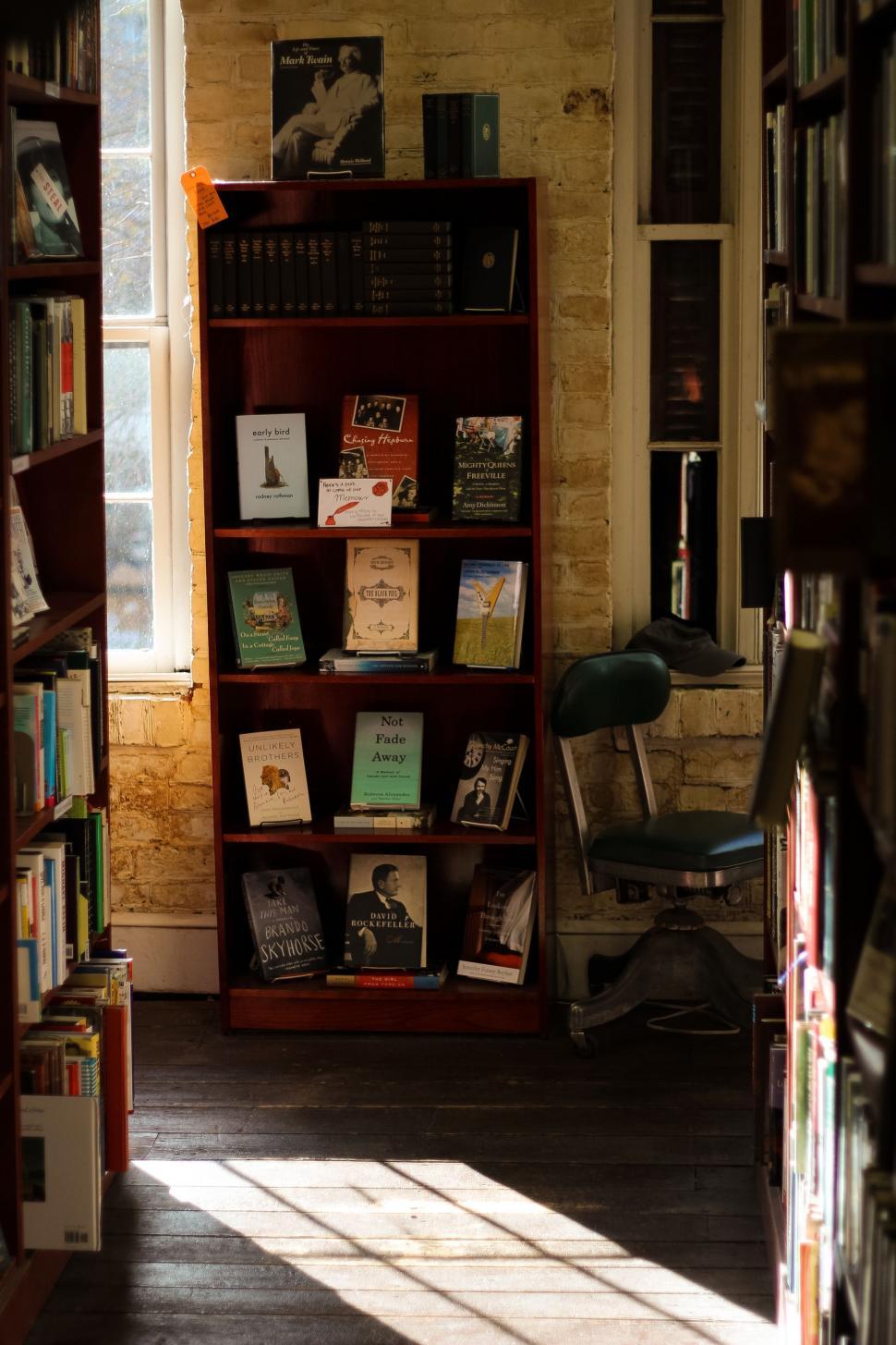 Free Image of Bookshelf Filled With Books Next to Window 