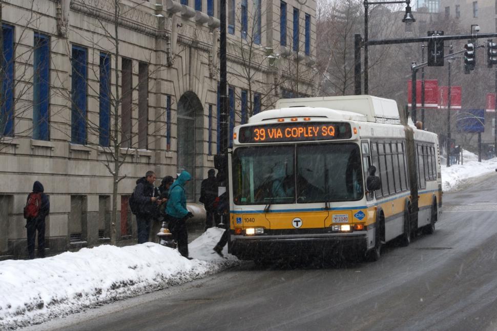 Free Image of Yellow and White Bus Driving on Snow Covered Street 