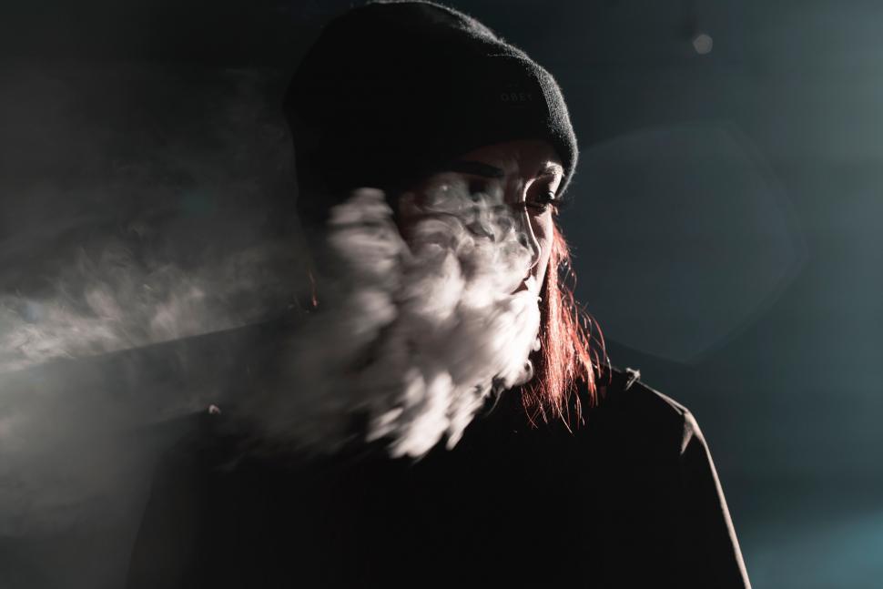 Free Image of Person in a Black Hoodie Smoking a Cigarette 