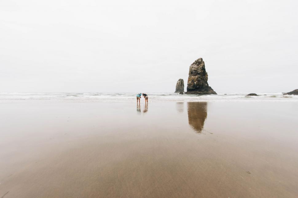 Free Image of Couple Standing on Top of Sandy Beach 
