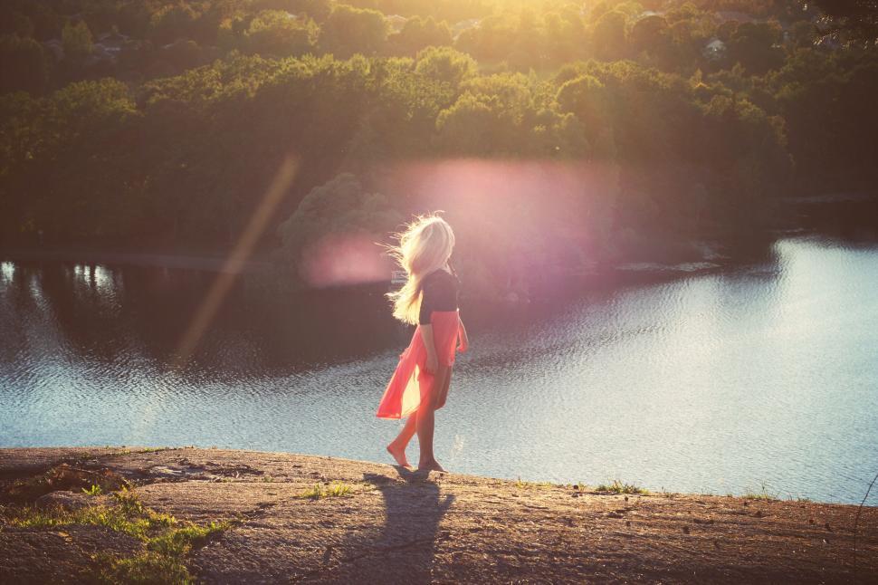 Free Image of Woman in Red Dress Looking Out Over Lake 