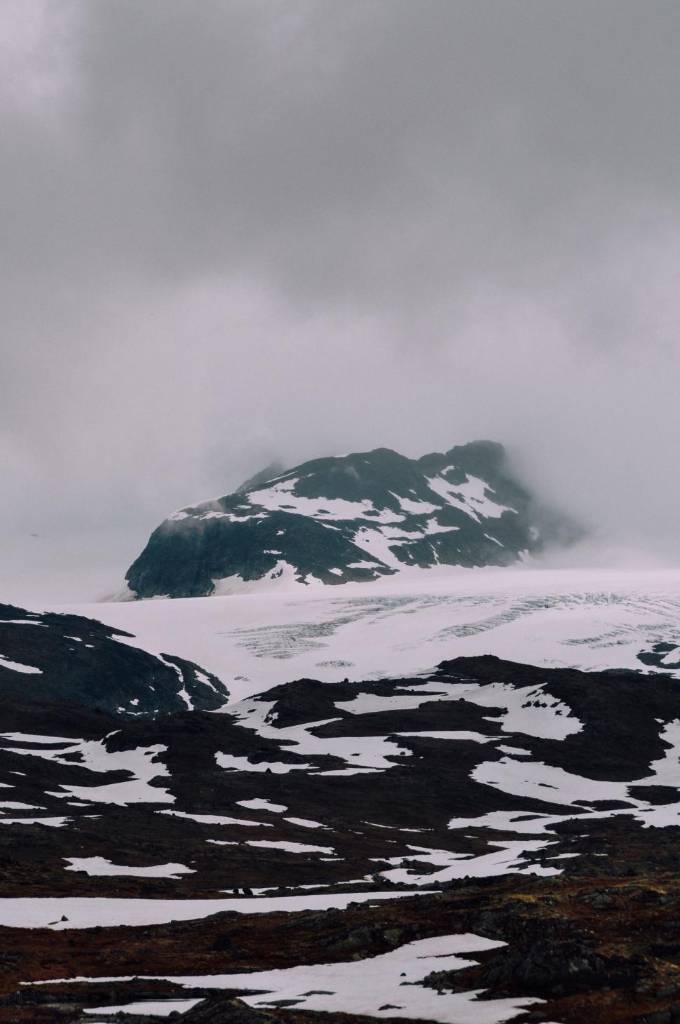 Free Image of Snow-Covered Mountain Amidst Clouds on Cloudy Day 