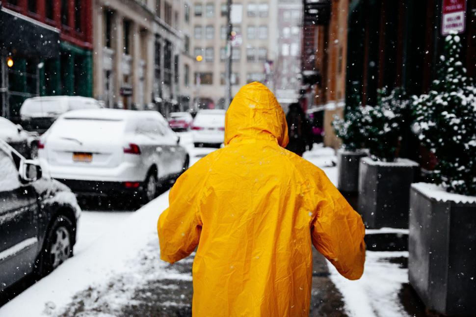 Free Image of Person in Yellow Raincoat Walking Down Snowy Street 