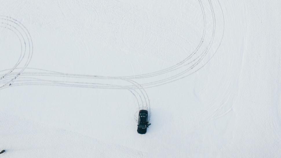 Free Image of Black Car Driving Down Snow-Covered Road 