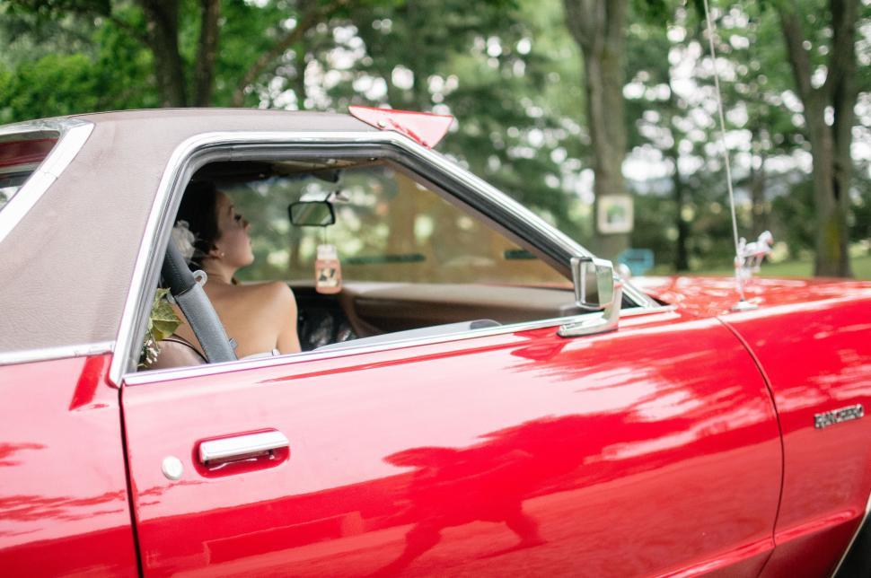 Free Image of Woman Driving Red Car Through Forest 