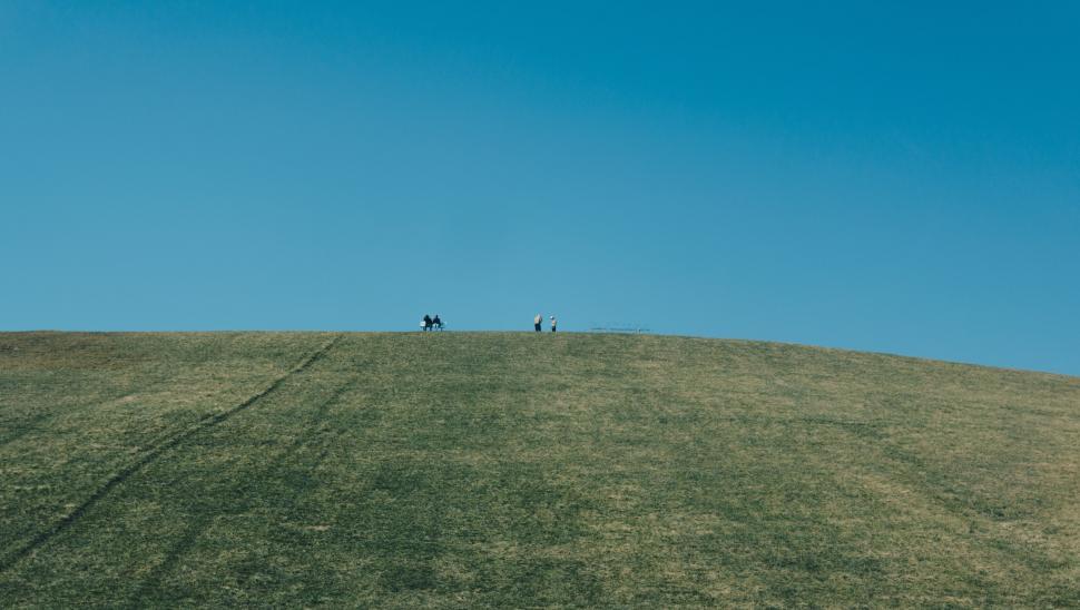 Free Image of Couple Standing on Grass-Covered Hill 