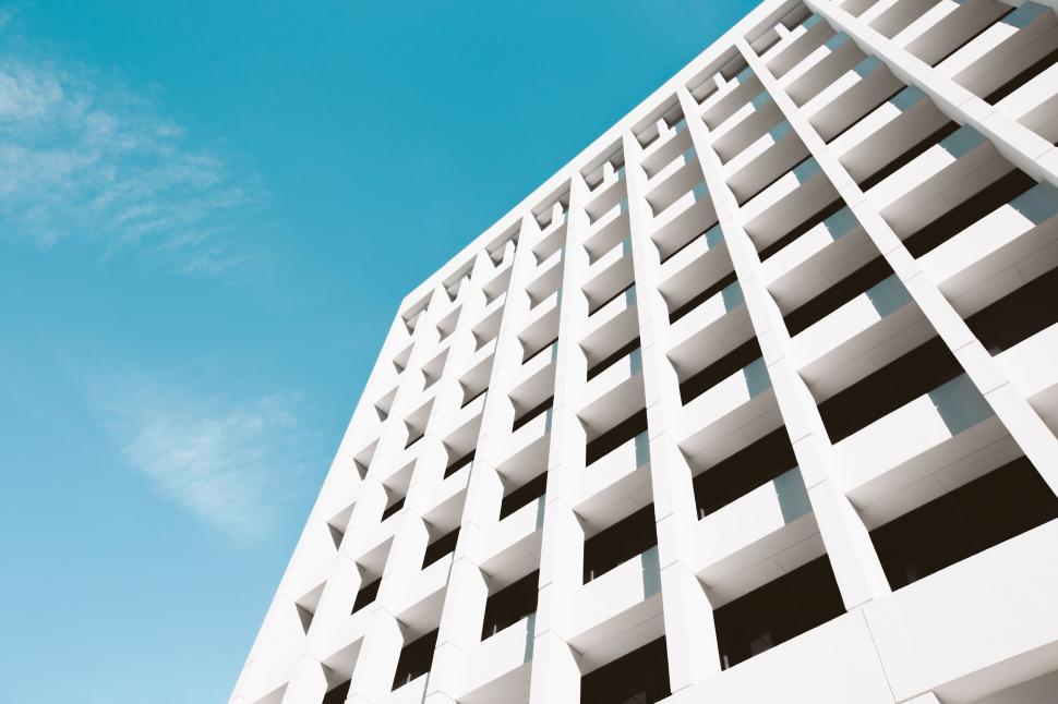 Free Image of Tall White Building Against Blue Sky 