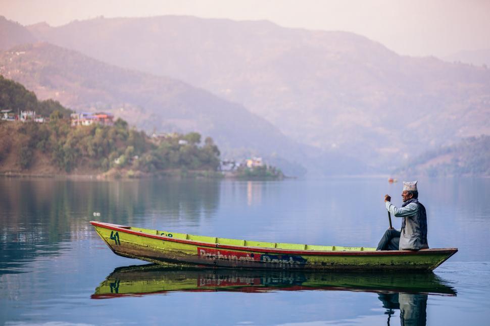 Free Image of Man Sitting in Yellow Boat on Lake 