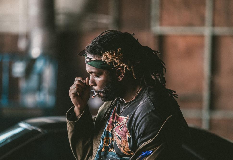 Free Image of Man With Dreadlocks Talking on a Cell Phone 