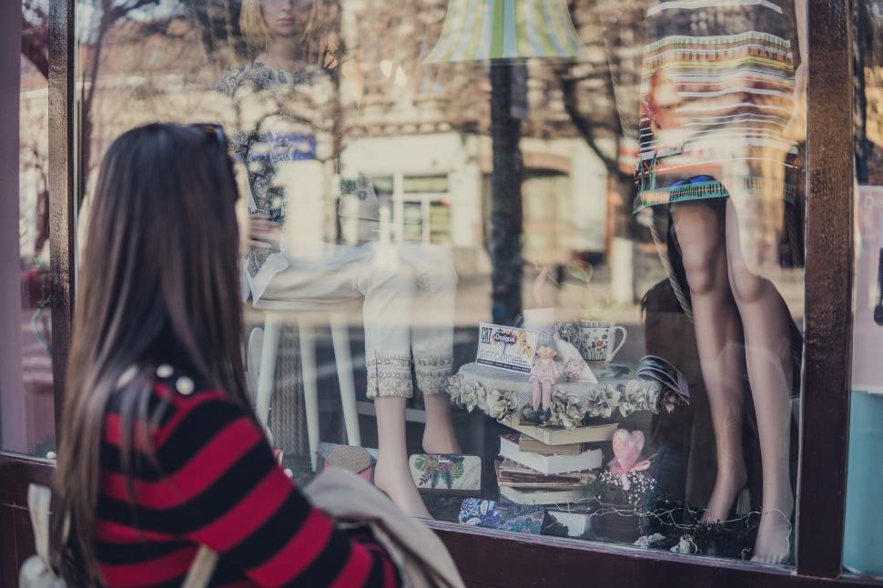 Free Image of Woman Looking in Window at Mannequin 