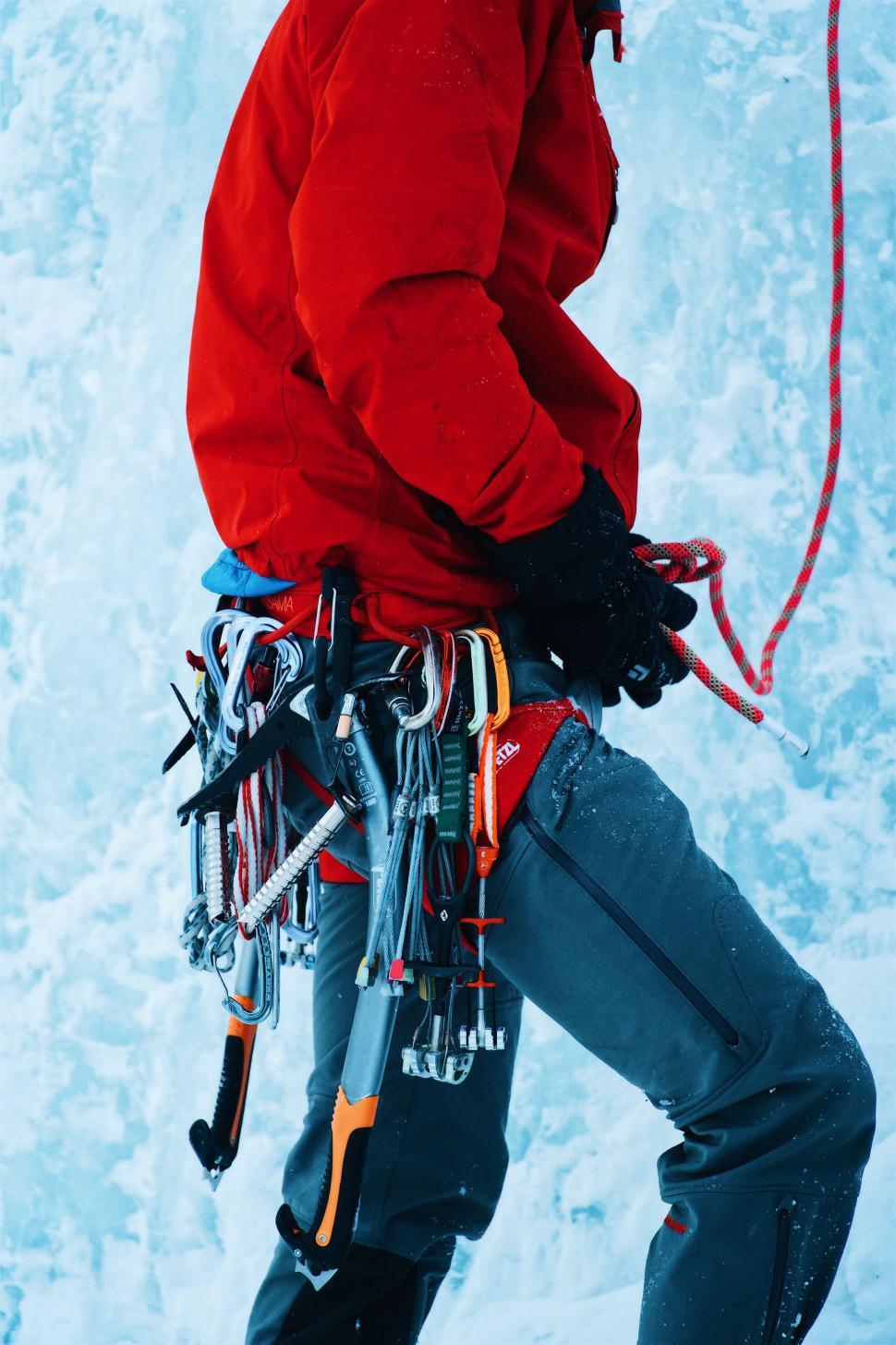 Free Image of Man in Red Jacket Holding Pair of Skis 