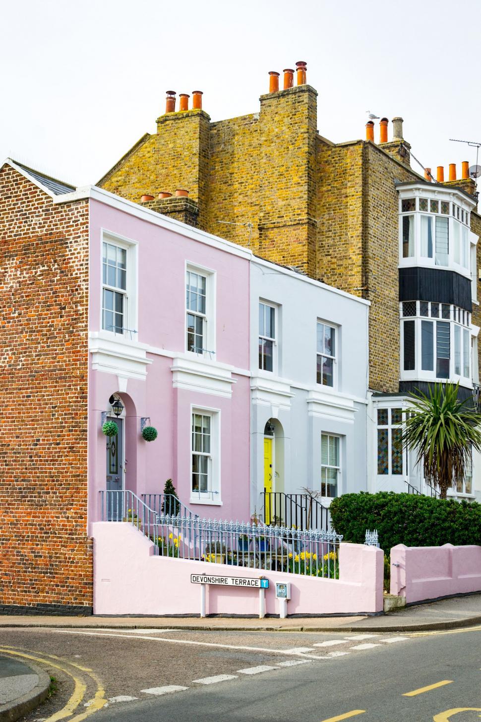 Free Image of Row of Pastel Houses on a Street Corner 