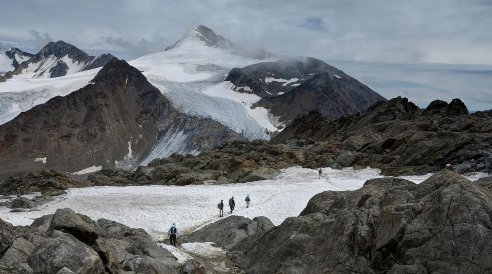 Free Image of Group of People Walking Up Snow Covered Mountain 
