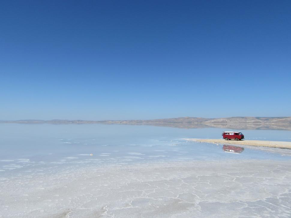 Free Image of Red Truck Driving Across Large Body of Water 