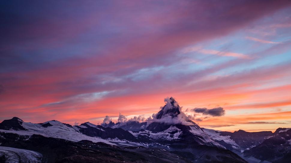 Free Image of Snow Covered Mountain With Sunset in the Background 