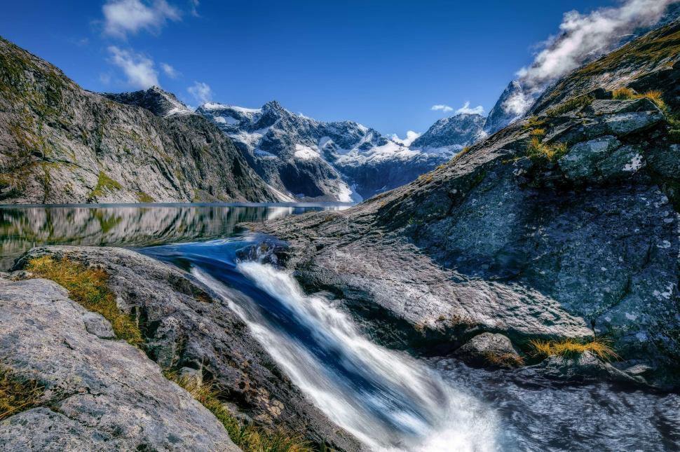 Free Image of Stream Running Through Valley Surrounded by Mountains 