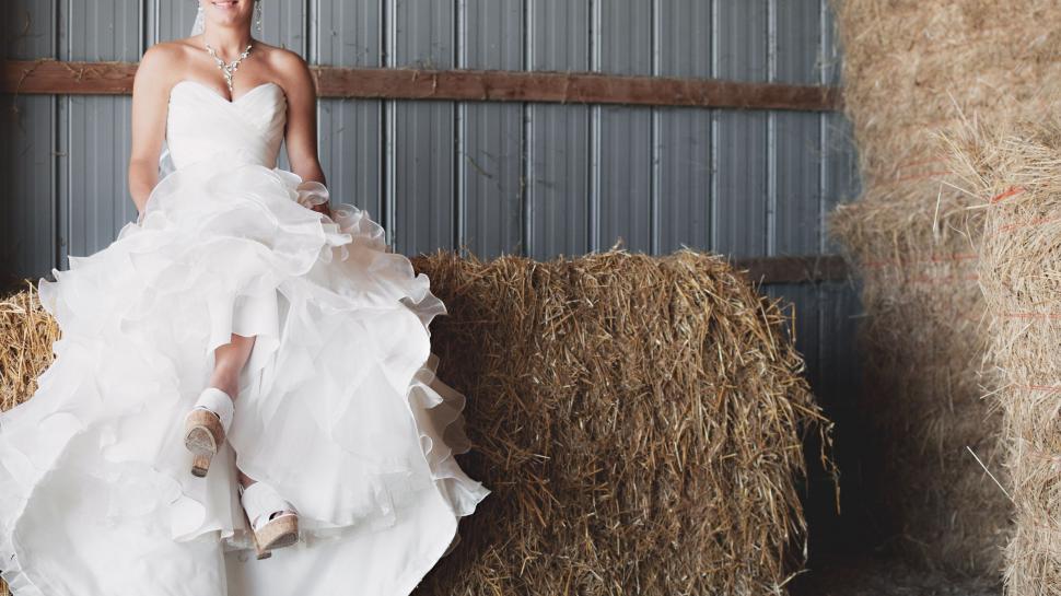 Free Image of Woman in White Dress Next to Hay Bales 