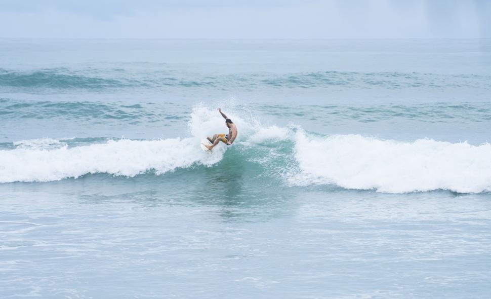 Free Image of Person Riding a Wave on Surfboard 