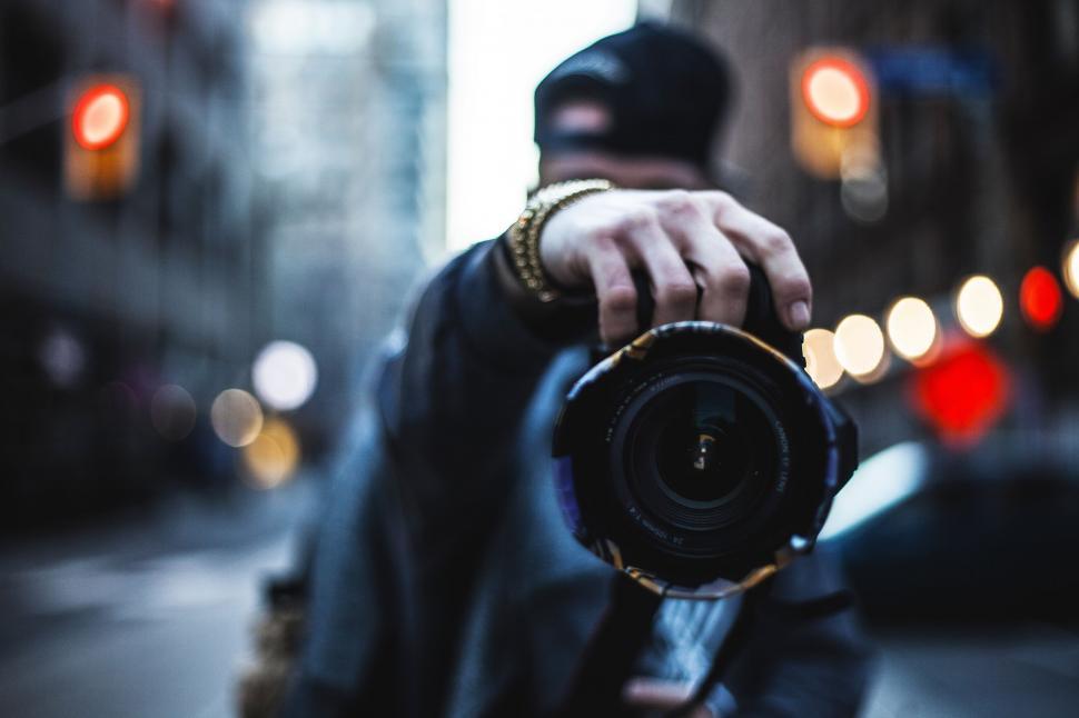 Free Image of Man Holding Camera on City Street 