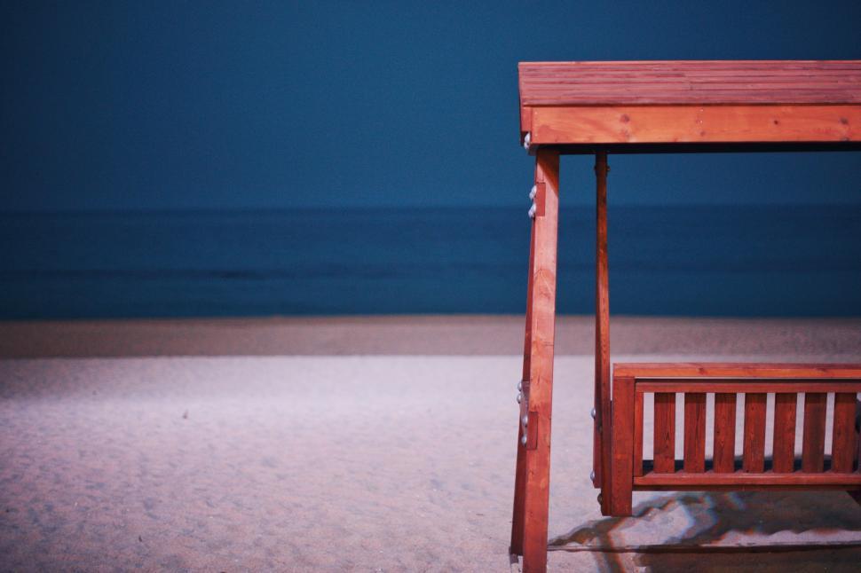 Free Image of Wooden Bench on Sandy Beach 