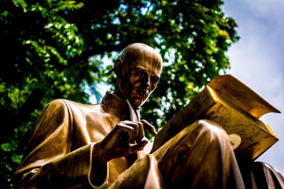 Free Image of Bronze Statue of a Man Reading a Book 