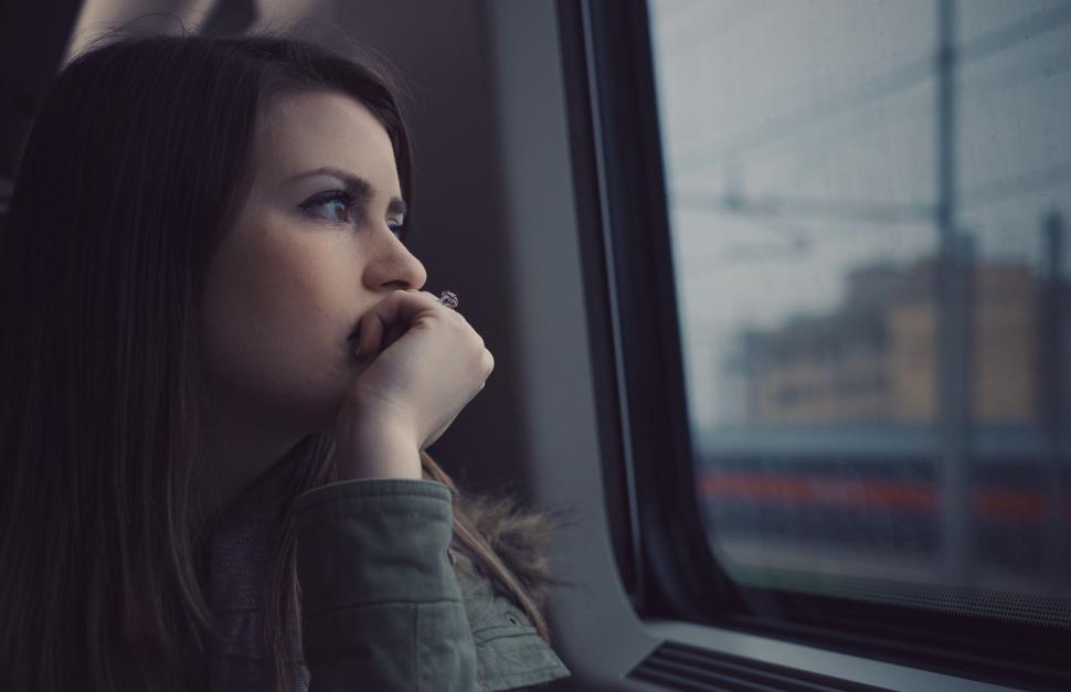 Free Image of Woman Sitting on Train Looking Out Window 