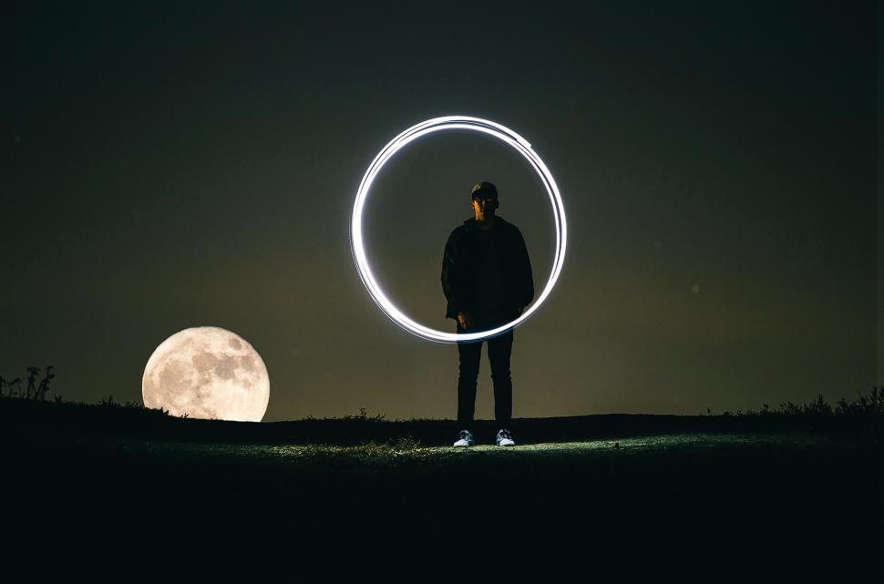 Free Image of Man Standing in Front of Full Moon 
