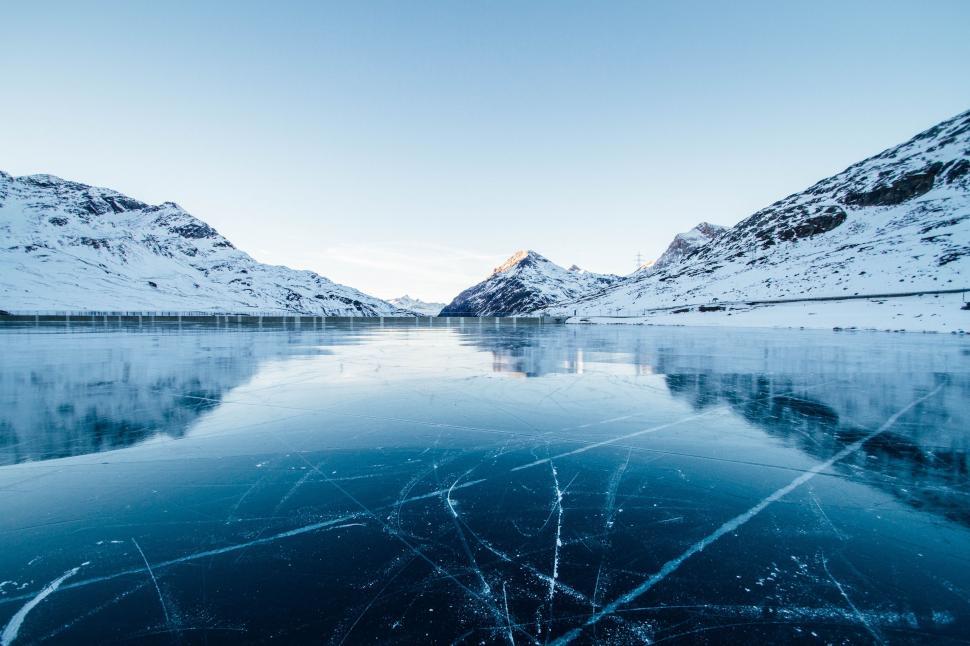Free Image of Frozen Lake Surrounded by Snow Covered Mountains 