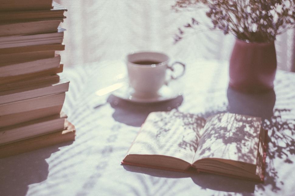 Free Image of A Stack of Books Next to a Cup of Coffee 