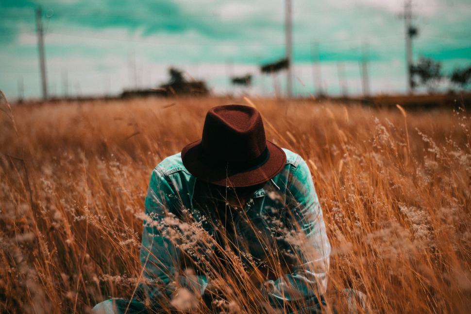 Free Image of Person Sitting in Field With Hat On 