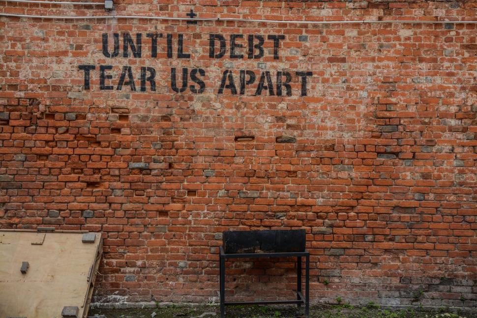 Free Image of Sign on Brick Wall: Until Debt Tear Us Apart 