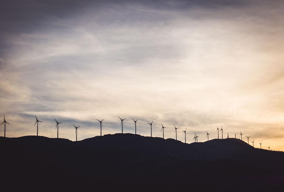 Free Image of Group of Windmills on Hill Under Cloudy Sky 