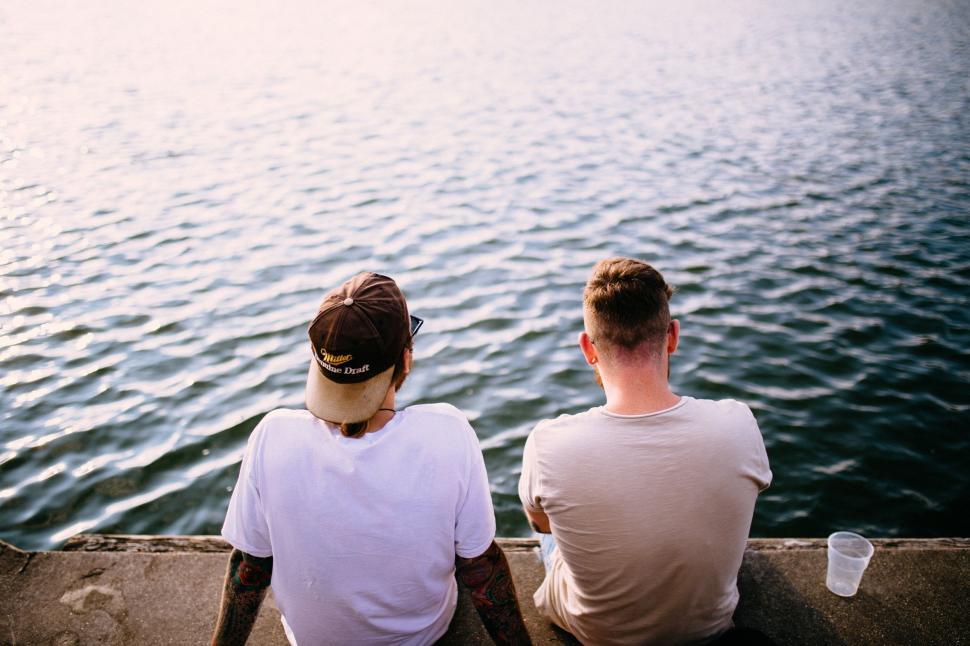 Free Image of Couple Sitting on Top of Pier 
