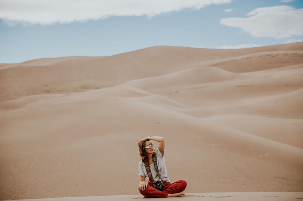 Free Image of Woman Sitting in the Middle of a Desert 