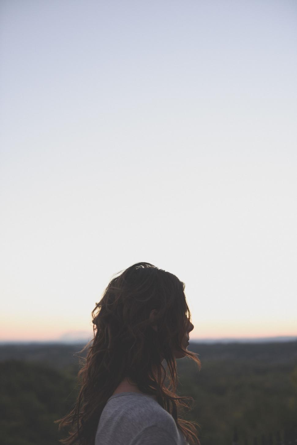 Free Image of Woman Standing in Front of Mountain at Sunset 