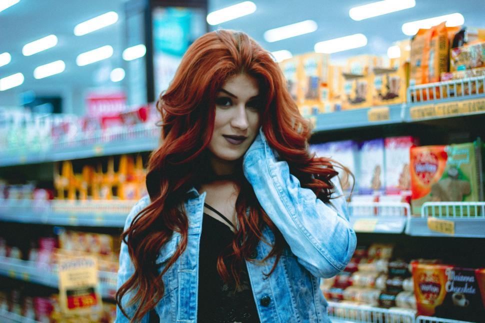 Free Image of Woman With Red Hair Standing in Store Aisle 