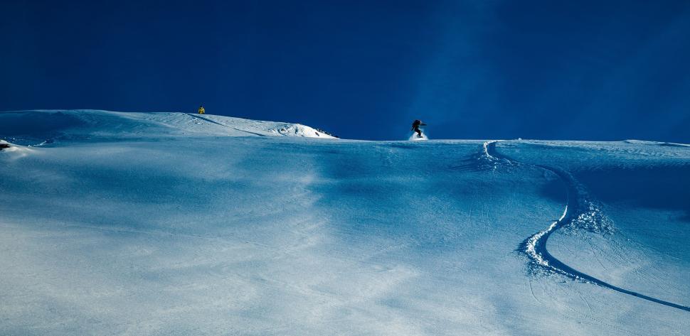 Free Image of Snowboarder Descending Snowy Hill 