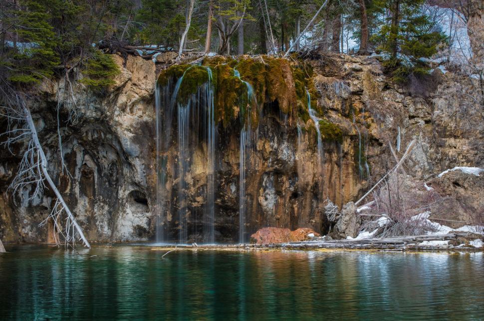 Free Image of Small Waterfall in the Middle of a Body of Water 