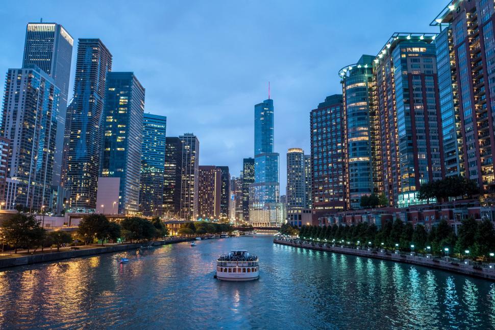 Free Image of Boat Traveling Down River Next to Tall Buildings 