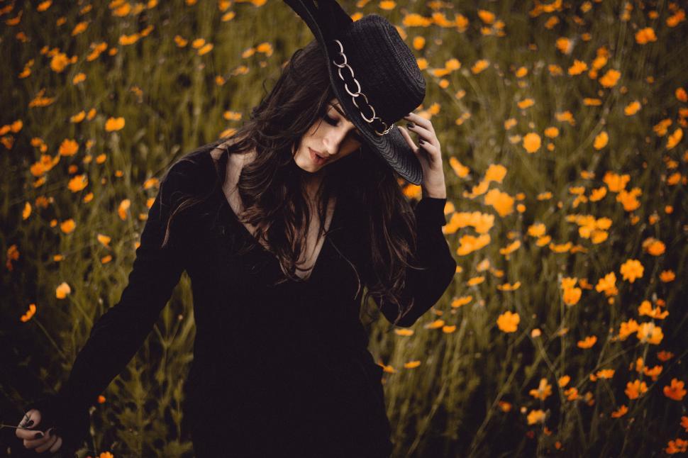 Free Image of Woman Walking Through Field With Hat 