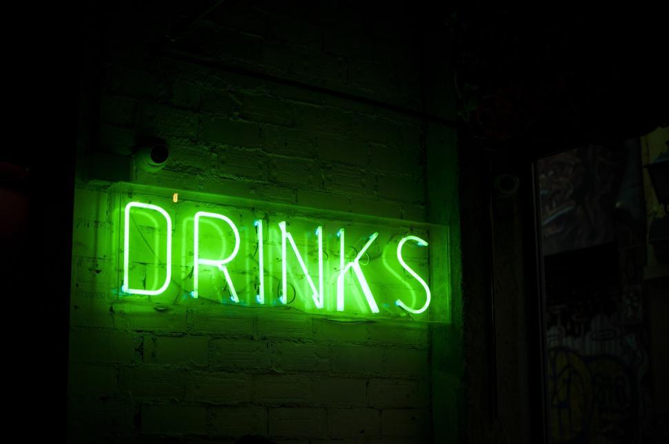 Free Image of Neon Sign Reading Drinks on Brick Wall 